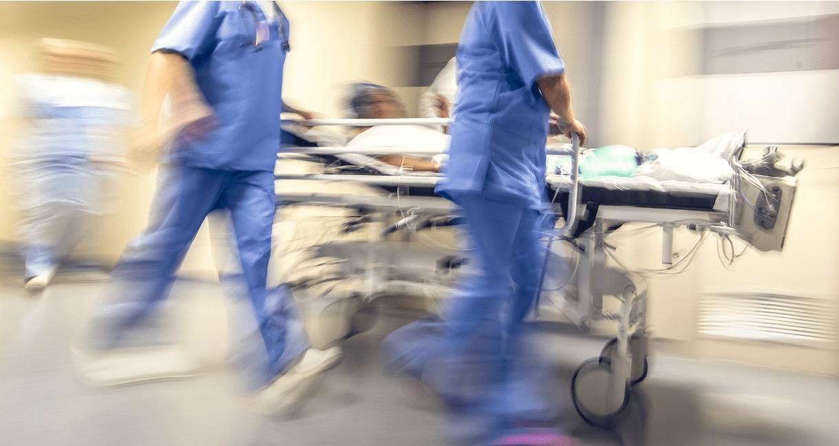 Doctors and nurses pulling hospital trolley,
