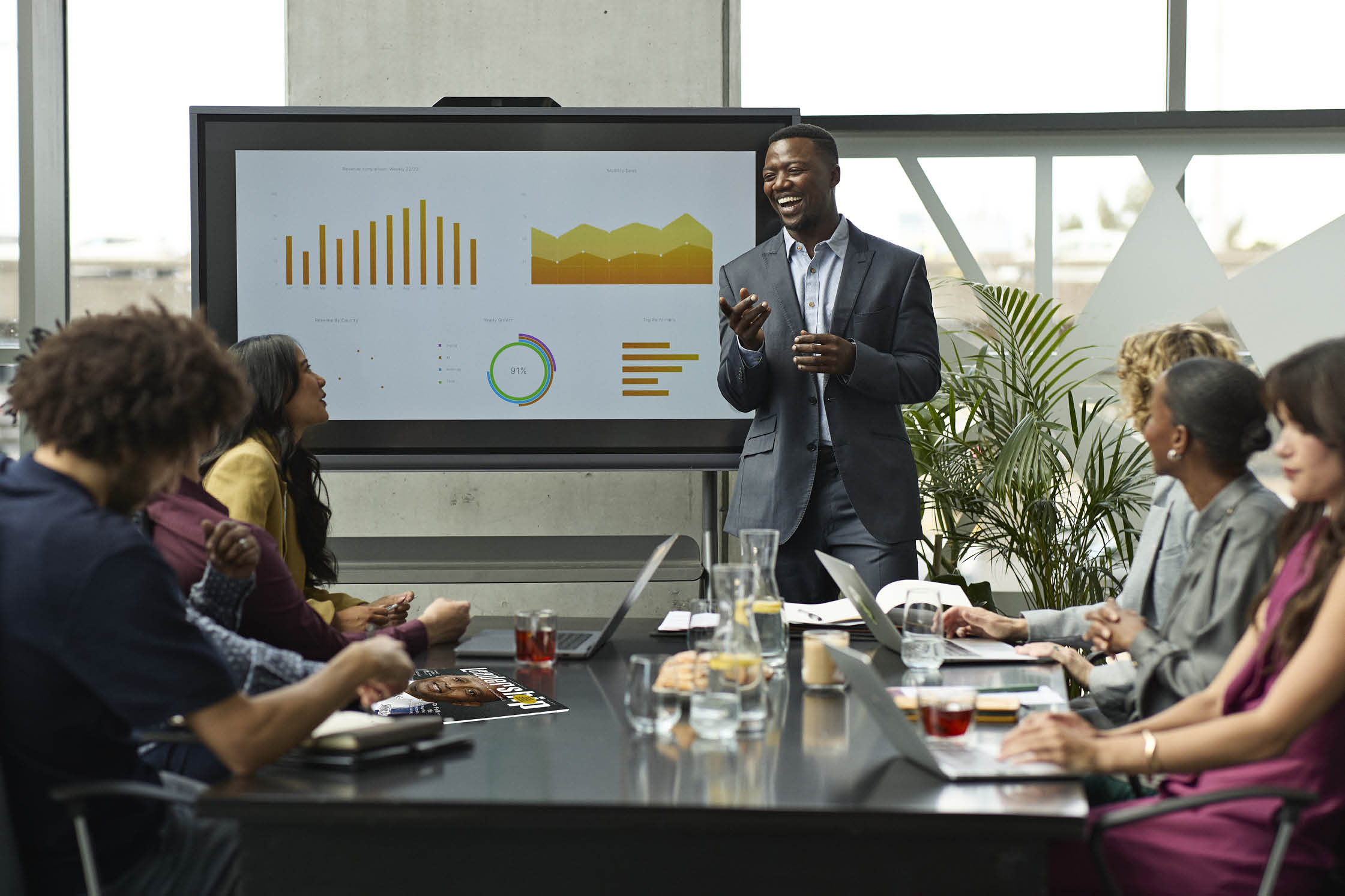 Happy businessman laughing during meeting with coworkers at office